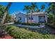Charming pink single story home with tidy landscaping and sidewalk entry, accented by palm trees at 805 Bruce Ave, Clearwater Beach, FL 33767