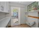 Functional laundry area with white cabinetry, countertop, and access to the backyard at 805 Bruce Ave, Clearwater Beach, FL 33767