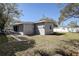 Cozy home featuring a spacious backyard with ample sunlight and concrete walkway at 813 Helena Dr, Largo, FL 33770