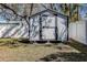 Backyard storage shed with grey walls and dark trim surrounded by white fencing at 813 Helena Dr, Largo, FL 33770