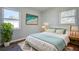 Bright bedroom with wood floors, white bedding, and two windows bringing in natural light at 813 Helena Dr, Largo, FL 33770
