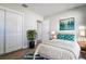 Bedroom with white bedding, coordinated decor, closet and bathroom access, and wood-look flooring at 813 Helena Dr, Largo, FL 33770