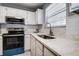 Close-up of kitchen with updated appliances, modern sink fixtures, and bright natural light at 813 Helena Dr, Largo, FL 33770