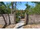 Backyard area enclosed by a rustic wooden fence and open gate at 8423 Jackson Springs Rd, Tampa, FL 33615