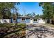 Charming single-story home with blue exterior, white trim, and a well-manicured lawn on a sunny day at 8423 Jackson Springs Rd, Tampa, FL 33615