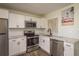 Modern kitchen features stainless steel appliances, white cabinetry, and tiled backsplash at 8423 Jackson Springs Rd, Tampa, FL 33615