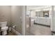 Main bathroom featuring double vanity, shower, toilet, and neutral paint at 8609 Winning Fields Rd, New Port Richey, FL 34655