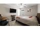 Neutral bedroom features a ceiling fan and a television mounted on the wall at 8609 Winning Fields Rd, New Port Richey, FL 34655