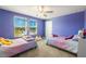 Shared ' bedroom with two beds, a ceiling fan and large windows allowing ample sunlight at 8609 Winning Fields Rd, New Port Richey, FL 34655