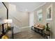 Bright foyer with a staircase, tiled floors, and a bench, creating a welcoming entrance at 8609 Winning Fields Rd, New Port Richey, FL 34655