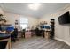 Well-lit home office with dual monitors, shelving, and a large window at 8609 Winning Fields Rd, New Port Richey, FL 34655