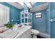 Cozy blue bathroom with tiled shower, offering a serene and functional space at 1032 Jambalana Dr, Holiday, FL 34691