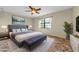 Well-lit bedroom featuring a ceiling fan, bench, and contemporary decor for a comfortable and stylish living space at 1032 Jambalana Dr, Holiday, FL 34691