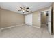 Empty bedroom features a closet with sliding doors, tile floors and a ceiling fan with a light at 1032 Jambalana Dr, Holiday, FL 34691