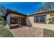 Exterior view showing a brick patio and screened-in porch, blending indoor-outdoor living at 1032 Jambalana Dr, Holiday, FL 34691