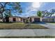 Charming single-story home with a well-maintained front yard, mature tree, and a cozy, inviting facade at 1032 Jambalana Dr, Holiday, FL 34691
