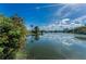 Scenic lake view with lush greenery, blue skies, and reflections at 1032 Jambalana Dr, Holiday, FL 34691