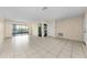 Spacious living room features tile flooring, neutral color palette, and sliding glass doors to the backyard at 1032 Jambalana Dr, Holiday, FL 34691