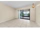 Open living room with tile floors and sliding glass doors leading to a screened porch and scenic lake view at 1032 Jambalana Dr, Holiday, FL 34691