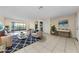 Bright, staged living room with tile floors, neutral walls, and large sliding glass doors for natural light at 1032 Jambalana Dr, Holiday, FL 34691