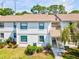 Charming two-story condo building with well-maintained landscaping, colorful flowers, and stairs to the unit entrance at 106 Meadow Ln # 106, Oldsmar, FL 34677