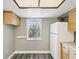 Bright kitchen with a large window, white appliances, light wood cabinets, and a gray accent wall at 106 Meadow Ln # 106, Oldsmar, FL 34677