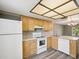 Traditional-style kitchen with wood cabinets, white appliances, and plenty of counter space at 106 Meadow Ln # 106, Oldsmar, FL 34677