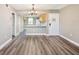 Open living and dining area features a kitchen view, gray walls, wood floors, and a modern chandelier at 106 Meadow Ln # 106, Oldsmar, FL 34677