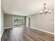 Bright living room features gray walls, wood floors, a chandelier, and a sliding glass door to a balcony at 106 Meadow Ln # 106, Oldsmar, FL 34677