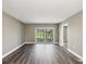 Cozy living room features gray walls, wood floors, and a sliding glass door to a balcony overlooking trees at 106 Meadow Ln # 106, Oldsmar, FL 34677