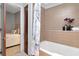 Bathroom with beige tile, shower over tub, and adjacent view into bedroom at 111 N 12Th St # 1426, Tampa, FL 33602