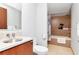 Bathroom featuring a vanity sink, toilet, and shower over tub with tan tile surround at 111 N 12Th St # 1426, Tampa, FL 33602