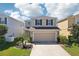 Beautiful two-story home featuring a well-maintained lawn, two-car garage, and classic architectural details at 11301 Hudson Hills Ln, Riverview, FL 33579