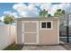 Backyard shed features neutral siding, a single window, and a large door at 11301 Hudson Hills Ln, Riverview, FL 33579