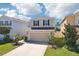 Two-story home with a two-car garage, well-manicured lawn, and decorative landscaping in front at 11301 Hudson Hills Ln, Riverview, FL 33579