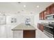 Open concept kitchen with island, stainless appliances, and granite countertops at 11301 Hudson Hills Ln, Riverview, FL 33579