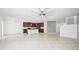 Bright living room with open floor plan, tile flooring, ceiling fan, and kitchen with island at 11301 Hudson Hills Ln, Riverview, FL 33579