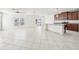 Bright living room with white tile flooring, ceiling fan, and kitchen view, creating an open and airy atmosphere at 11301 Hudson Hills Ln, Riverview, FL 33579
