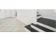 Hallway with white tile flooring leading to a staircase with dark wood treads and white risers at 11301 Hudson Hills Ln, Riverview, FL 33579