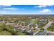 Aerial shot showcasing a neighborhood with neatly arranged homes, mature trees, and a tranquil pond at 11822 Crawford Parrish Ln, Parrish, FL 34219
