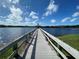 Scenic view of a lake from the end of a long wooden dock under a blue sky at 11822 Crawford Parrish Ln, Parrish, FL 34219
