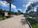 Elegant entrance to the community lined with palm trees and brick paved path, welcoming residents at 11822 Crawford Parrish Ln, Parrish, FL 34219