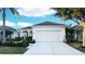 Charming single-story home showcasing a well-maintained lawn, manicured shrubbery, and an attached two-car garage at 11822 Crawford Parrish Ln, Parrish, FL 34219