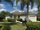 Beautifully landscaped front yard featuring lush green grass and mature palm trees against a clear blue sky at 11822 Crawford Parrish Ln, Parrish, FL 34219
