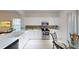 Bright kitchen features modern appliances, white cabinets, and tiled backsplash at 11822 Crawford Parrish Ln, Parrish, FL 34219
