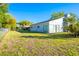 Spacious backyard with healthy green grass and side view of the home at 13116 Sheridan Dr, Hudson, FL 34667