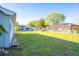 Well-maintained backyard with green lawn, privacy fence, and screened in pool at 13116 Sheridan Dr, Hudson, FL 34667