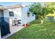 Backyard with a small patio, grill, lawn, and landscaping next to house at 13116 Sheridan Dr, Hudson, FL 34667