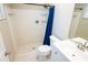 Tiled bathroom featuring a shower with a blue curtain, toilet, and vanity with a sink at 13116 Sheridan Dr, Hudson, FL 34667