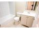 Bright bathroom with white tiled tub, toilet, vanity and cabinet with a clean, functional design at 13116 Sheridan Dr, Hudson, FL 34667